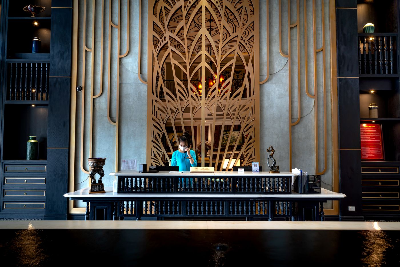A receptionist at the front desk of a hotel lobby