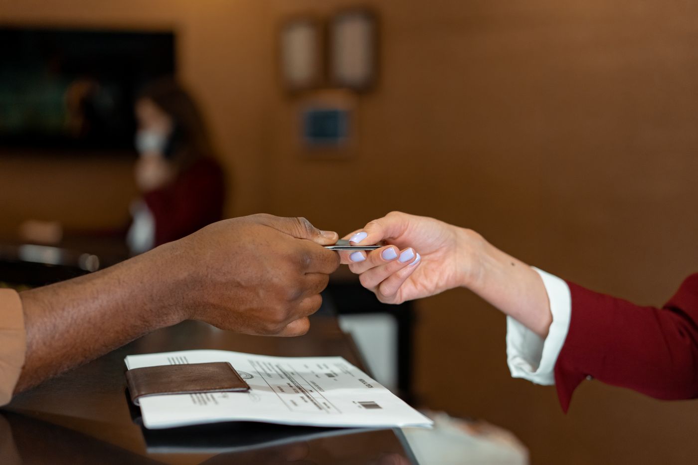 A guest handing over a card at the front desk