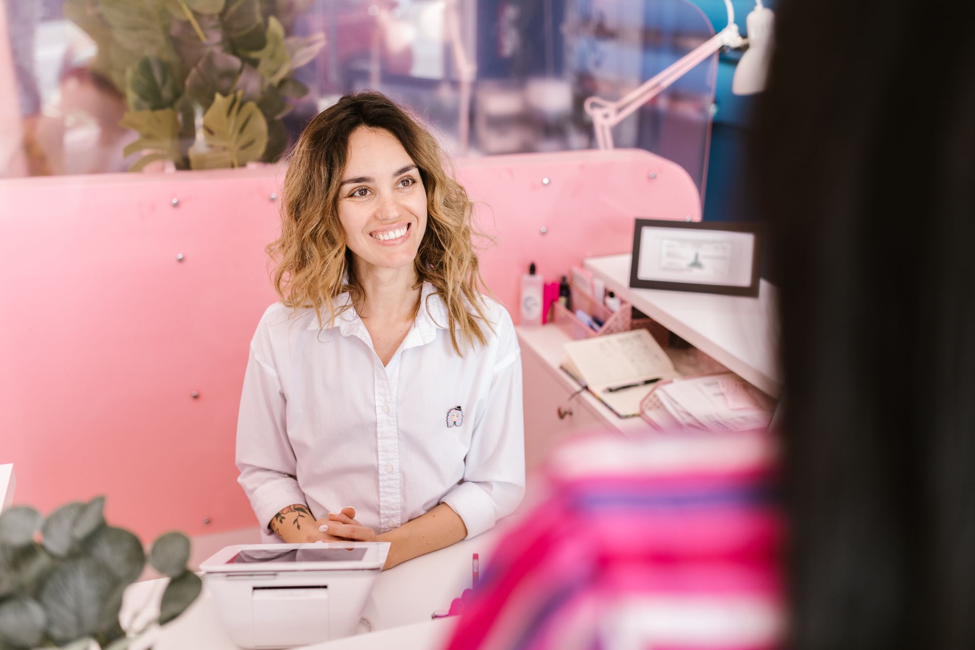 A smiling receptionist at a hotel front desk